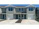Two-story townhome featuring a one-car garage and manicured landscaping at 6627 Leo Ln, St Cloud, FL 34773