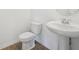 Bathroom with a pedestal sink, round mirror, tiled floor, and a comfort height toilet at 6723 Sherpa Trl, St Cloud, FL 34771