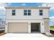 Two-story home with a two-car garage, manicured landscaping, and neutral-colored accents at 6723 Sherpa Trl, St Cloud, FL 34771