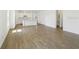 Open-concept living space featuring wood-look flooring and a view into the modern kitchen at 6723 Sherpa Trl, St Cloud, FL 34771