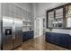 Bright kitchen features stainless steel appliances, blue cabinets, and stylish patterned wallpaper at 7053 Painted Bunting Way, St Cloud, FL 34773