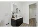 Modern bathroom showcasing the black vanity, illuminated mirror, and stylish wood look flooring at 7124 Turquoise Ln, Orlando, FL 32807