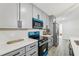 Modern kitchen features gray cabinets, quartz countertops, and stainless steel appliances at 7124 Turquoise Ln, Orlando, FL 32807