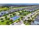 Community aerial view showcasing modern townhomes, sports courts, and extensive landscaping for an active lifestyle at 877 Ocean Course Ave, Davenport, FL 33896