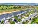 Aerial view of a vibrant community with a golf course, pond, and modern townhomes in a suburban setting at 877 Ocean Course Ave, Davenport, FL 33896