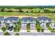 Luxury townhomes with garages on tree-lined street adjacent to lush green golf course, viewed aerially at 877 Ocean Course Ave, Davenport, FL 33896