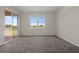 Carpeted bedroom with sliding glass doors to the covered porch and window at 877 Ocean Course Ave, Davenport, FL 33896