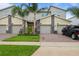 Modern townhomes feature stone accents, attached garages, and well-manicured lawns at 877 Ocean Course Ave, Davenport, FL 33896