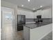 A modern kitchen features stainless appliances, white cabinetry and tile flooring at 877 Ocean Course Ave, Davenport, FL 33896
