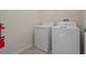 Laundry room showcasing washer, dryer, tile floor, and fire extinguisher at 877 Ocean Course Ave, Davenport, FL 33896