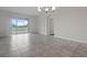 A well-lit living room features tile flooring and a sliding glass door to a patio at 877 Ocean Course Ave, Davenport, FL 33896