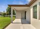 The covered back patio has a lawn and trees beyond at 921 Costa Mesa Ln, Kissimmee, FL 34744