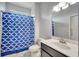 Functional bathroom with sink, toilet, and tub with blue patterned curtain, providing essential amenities at 921 Costa Mesa Ln, Kissimmee, FL 34744
