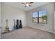 This bedroom has a large window with blinds, carpeted floors, and wall decor at 921 Costa Mesa Ln, Kissimmee, FL 34744