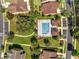 Aerial view of the community pool area featuring a swimming pool, cabanas, and surrounding green spaces at 921 Costa Mesa Ln, Kissimmee, FL 34744