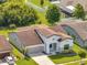 Exterior view featuring a well-maintained lawn, a two-car garage, and modern architectural details at 921 Costa Mesa Ln, Kissimmee, FL 34744