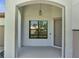Welcoming front porch with a covered entrance and modern light fixture at 921 Costa Mesa Ln, Kissimmee, FL 34744