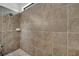 The walk-in shower features stylish brown tiling, offering a modern and easy-to-maintain bathing space at 921 Costa Mesa Ln, Kissimmee, FL 34744