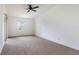 Cozy bedroom with neutral carpet, a ceiling fan, and sliding glass doors offering ample natural light at 10438 Sw 85Th Ct, Ocala, FL 34481