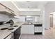 Efficient kitchen featuring white cabinetry, tiled flooring and a convenient layout with a view to the dining area at 10438 Sw 85Th Ct, Ocala, FL 34481
