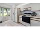 Bright kitchen with white cabinets, tiled floors, and a bay window offering plenty of natural light at 10438 Sw 85Th Ct, Ocala, FL 34481