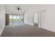 Light-filled living room with neutral carpet, ceiling fan and slider access to the screened patio at 10438 Sw 85Th Ct, Ocala, FL 34481