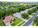 Aerial view showcasing house with lush landscaping, neighboring homes, and community streets at 1124 Hidden Blf, Clermont, FL 34711