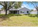 Well-maintained backyard showcasing the home's exterior and screened-in porch area at 1124 Hidden Blf, Clermont, FL 34711