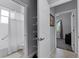 Open bathroom doorway, showing shelving, toilet, shower with grab bar, and access to another room at 1124 Hidden Blf, Clermont, FL 34711