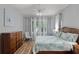 Cozy bedroom with wood floors, a floral comforter, and a large window for natural light at 1124 Hidden Blf, Clermont, FL 34711