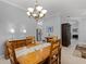 Bright dining room featuring a wooden table and chandelier with an open view to the kitchen at 1124 Hidden Blf, Clermont, FL 34711