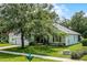 Beautifully landscaped single-Gathering home with lush green lawn and mature shade trees at 1124 Hidden Blf, Clermont, FL 34711