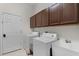 Well-equipped laundry room with modern washer, dryer, and sink, plus ample storage cabinets at 1124 Hidden Blf, Clermont, FL 34711