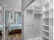Walk-in closet with built-in shelving, adjacent to a bedroom with wood floors at 1124 Hidden Blf, Clermont, FL 34711