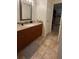 Bathroom with wood cabinets, granite countertops, a single sink, and ceramic floors at 11582 Westwood Blvd # 1428, Orlando, FL 32821