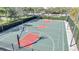 View of outdoor basketball court with green surface and lighting for night games, within a fenced area at 11937 Bianca Ln, Orlando, FL 32827