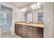 Bathroom featuring a double vanity with granite countertops and a view of the toilet and window at 11937 Bianca Ln, Orlando, FL 32827