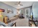 Bright, carpeted bedroom with a lounge area, desk, ceiling fan, and access to a screened lanai at 11937 Bianca Ln, Orlando, FL 32827