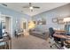Comfortable bedroom features a ceiling fan, lounge furniture, and an adjacent bathroom and office area at 11937 Bianca Ln, Orlando, FL 32827