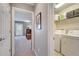 Hallway leading to a carpeted bedroom and the laundry room with a washer and dryer at 11937 Bianca Ln, Orlando, FL 32827