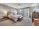 A serene main bedroom with a ceiling fan, a king bed, and French doors at 11937 Bianca Ln, Orlando, FL 32827