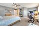 Bright main bedroom with a ceiling fan, a king bed, and a desk with office space at 11937 Bianca Ln, Orlando, FL 32827