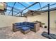 Screened-in patio with brick flooring and comfortable seating around the umbrella at 11937 Bianca Ln, Orlando, FL 32827