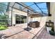 This screened-in patio features brick flooring, an umbrella, and comfortable seating at 11937 Bianca Ln, Orlando, FL 32827