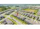 Wide aerial shot of a residential community featuring neatly arranged townhomes, green spaces, and a tranquil lake nearby at 13452 Sagestone Dr, Winter Garden, FL 34787