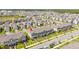 Expansive aerial view captures a vibrant neighborhood with rows of townhomes, manicured lawns, and ample parking at 13452 Sagestone Dr, Winter Garden, FL 34787
