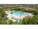 Overhead view of the pool area featuring a unique shape, lounge chairs, umbrellas, and lush landscaping at 13452 Sagestone Dr, Winter Garden, FL 34787