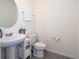 Half bathroom with pedestal sink, white toilet, and grey flooring at 13452 Sagestone Dr, Winter Garden, FL 34787