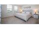 Bright bedroom features two windows with views, neutral décor, and plush carpet at 13452 Sagestone Dr, Winter Garden, FL 34787