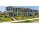 Charming row of townhomes, each featuring a covered entrance and beautifully landscaped front yards at 13452 Sagestone Dr, Winter Garden, FL 34787